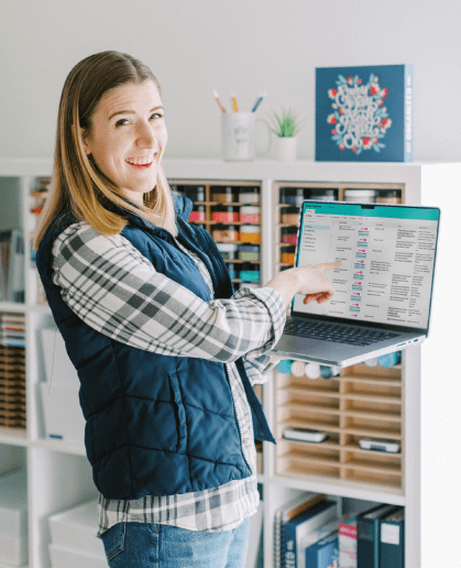 Tasha holding a laptop and pointing at the Cleaning Command Center on the screen
