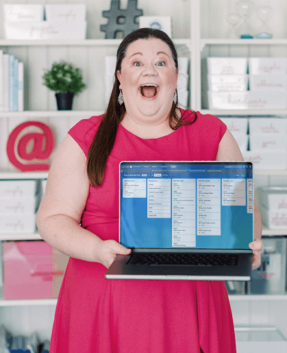 Laura excitedly holding her laptop with the Drag + Drop Meal Planner on the screen