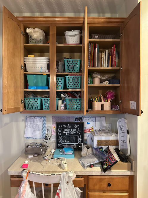 Messy craft area with a desk covered in supplies