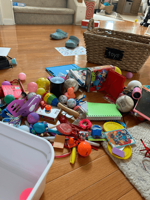 Toys scattered on the floor because they don't all fit in the toy bin