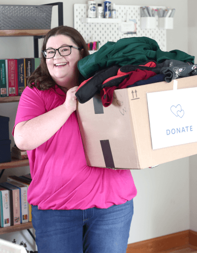 Laura holding a donate box full of clothes
