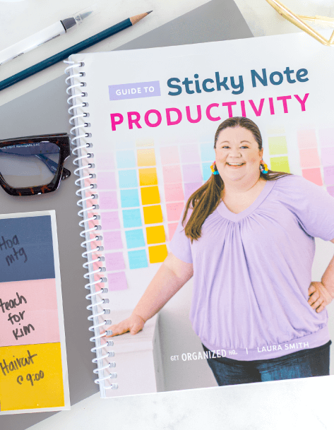 Spiral-bound Guide to Sticky Note Productivity surrounded by glasses, a laptop, and sticky notes