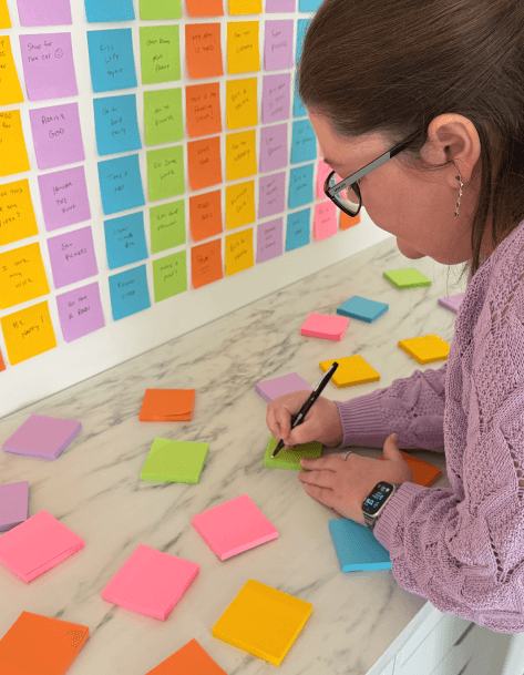 Laura writing on colorful sticky notes