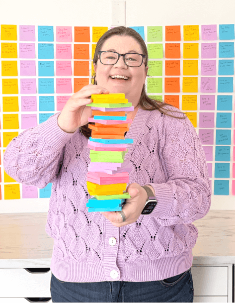 Laura holding a stack of colorful sticky notes